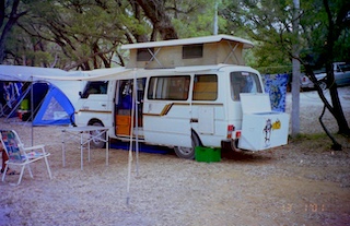 Spot the pop top camper van parked in a campsite.