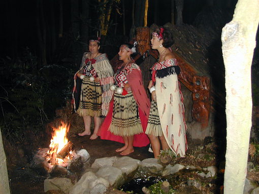 Women in Maori dress by fireside