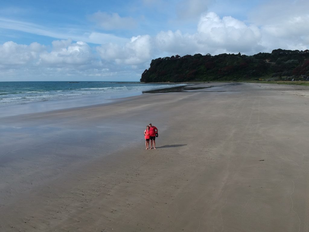 Drone shot of Sharon & David Schindler on a deserted Oruaiti Beach New Zealand