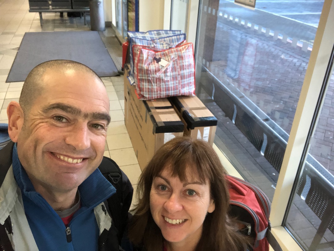 David and Sharon Schindler at Belfast bus station with bike boxes and luggage