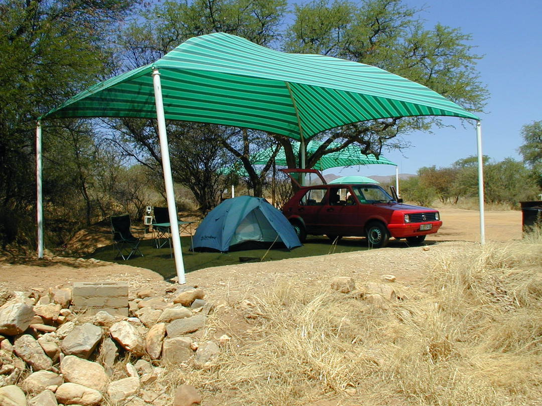 Campsite in Namibia with the tent and car underneath a sun shade