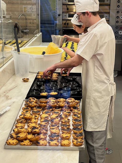 Chefs making trays of pastel de nata