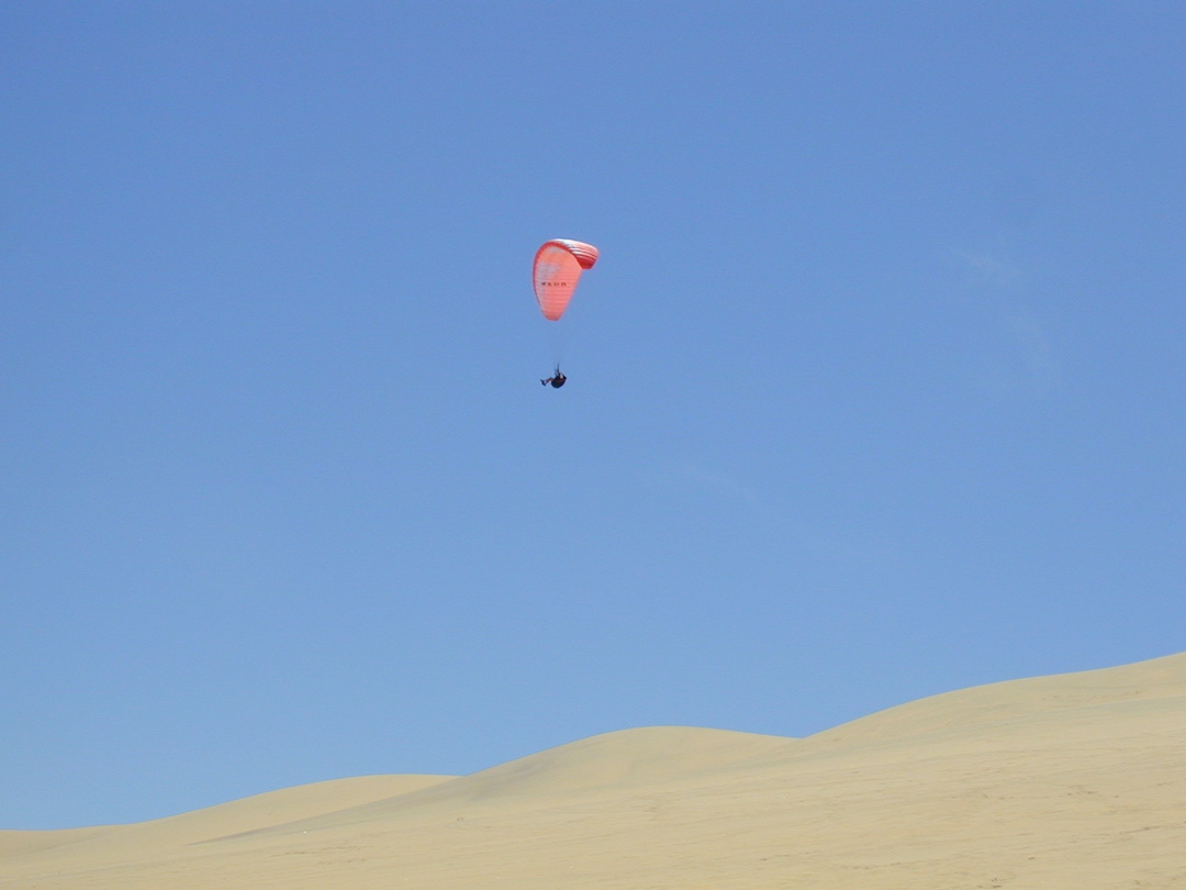 Dave in his paraglider soaring above the sand dunes in Swakopmund Namibia